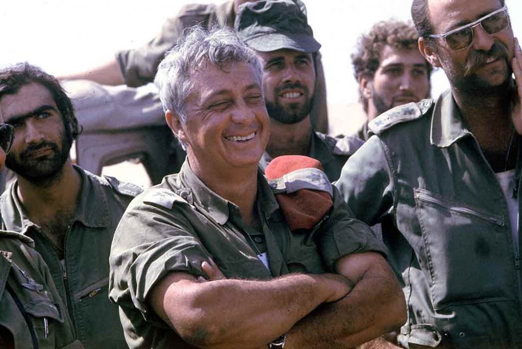GENERAL ARIEL SHARON LAUGHING WITH HIS WARRIORS DURING THE YOM KIPPUR WAR, SINAI DESERT 1973